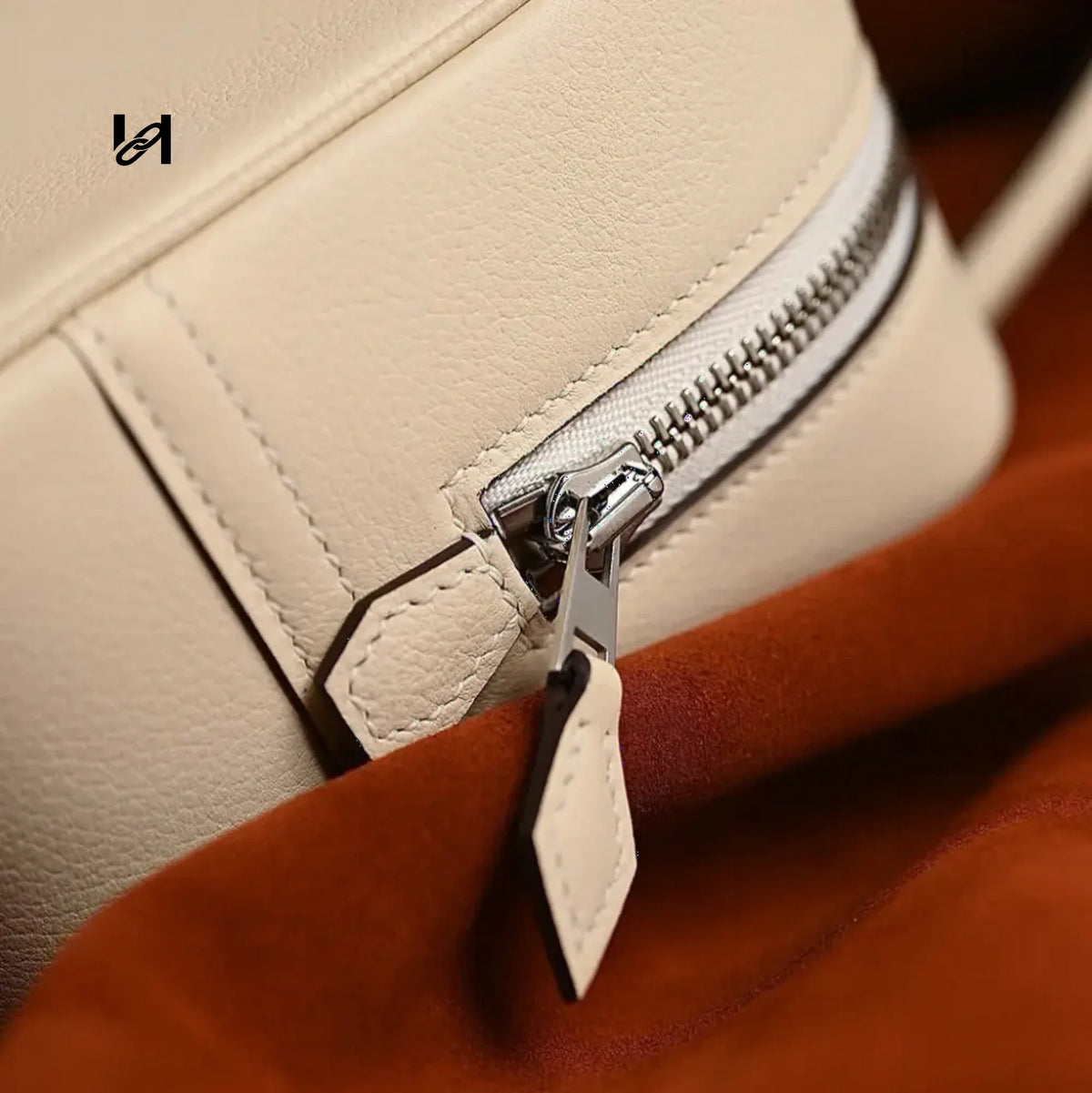 Stainless steel zipper slider and leather puller on a cream leather handbag